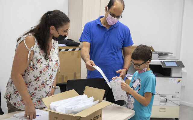 Des parents et des enfants de l'école "Cramim" reçoivent un test COVID-19 en kit à domicile avant l'ouverture de la nouvelle année scolaire, à Jérusalem, le 30 août 2021. (Crédit : Olivier Fitoussi/Flash90) Des parents et des enfants de l'école "Cramim" reçoivent un test COVID-19 en kit à domicile avant l'ouverture de la nouvelle année scolaire, à Jérusalem, le 30 août 2021. (Crédit : Olivier Fitoussi/Flash90)