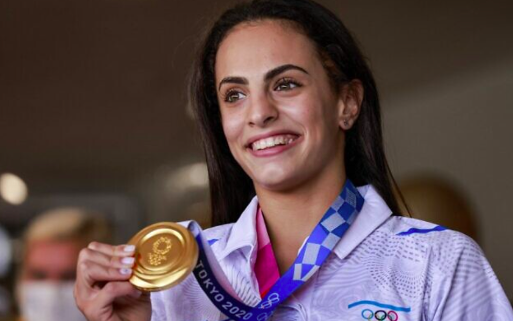 La médaillée d'or olympique Linoy Ashram à l'aéroport Ben Gurion après avoir remporté la médaille d'or en gymnastique rythmique aux Jeux olympiques du Japon, le 11 août 2021 (Crédit : Menahem KAHANA / AFP)