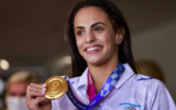 La médaillée d'or olympique Linoy Ashram à l'aéroport Ben Gurion après avoir remporté la médaille d'or en gymnastique rythmique aux Jeux olympiques du Japon, le 11 août 2021 (Crédit : Menahem KAHANA / AFP)