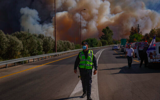 Des pompiers sur le site d'un feu de forêt à l'ouest de Jérusalem, le 15 août 2021. (Crédit : Yonatan Sindel/Flash90)