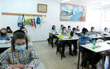 Des enfants Haredim de l'école ultra-orthodoxe Bnei Moshe Kretchnif portent des masques dans leur école de la ville de Rehovot, le 24 mai 2020. (Crédit : Yossi Zeliger/Flash90)