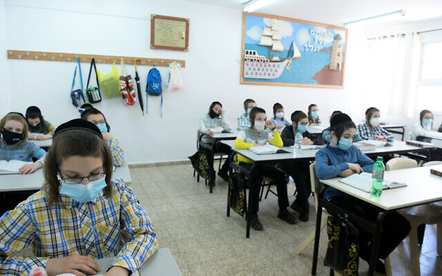 Des enfants Haredim de l'école ultra-orthodoxe Bnei Moshe Kretchnif portent des masques dans leur école de la ville de Rehovot, le 24 mai 2020. (Crédit : Yossi Zeliger/Flash90) Des enfants Haredim de l'école ultra-orthodoxe Bnei Moshe Kretchnif portent des masques dans leur école de la ville de Rehovot, le 24 mai 2020. (Crédit : Yossi Zeliger/Flash90)