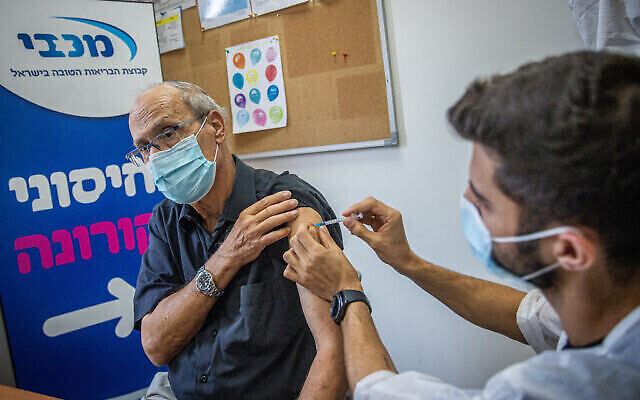 Un Israélien se fait administrer une piqûre de rappel dans un centre de vaccination de la caisse Maccabi, le 1er août 2021. (Crédit : Yonatan Sindel/Flash90) Un Israélien se fait administrer une piqûre de rappel dans un centre de vaccination de la caisse Maccabi, le 1er août 2021. (Crédit : Yonatan Sindel/Flash90)