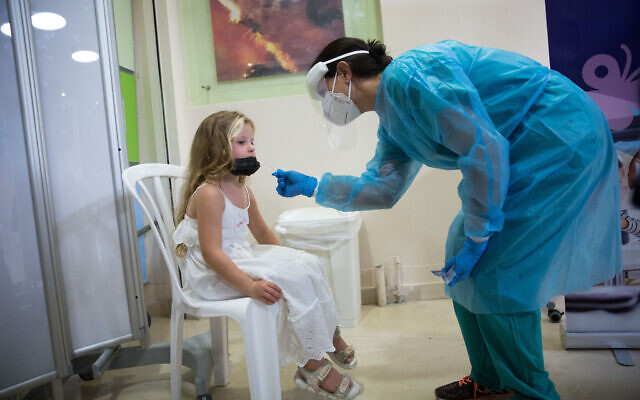 Une petite fille se fait dépister au coronavirus à l'hôpital Sheba de Ramat Gan, le 2 août 2021. (Crédit : Miriam Alster/FLASH90) Une petite fille se fait dépister au coronavirus à l'hôpital Sheba de Ramat Gan, le 2 août 2021. (Crédit : Miriam Alster/FLASH90)