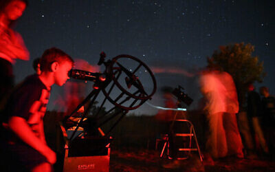 Des Israéliens regardent les étoiles pendant une pluie de météorites au-dessus du plateau du Golan, le 13 août 2021. (Crédit : Michael Giladi/Flash90)