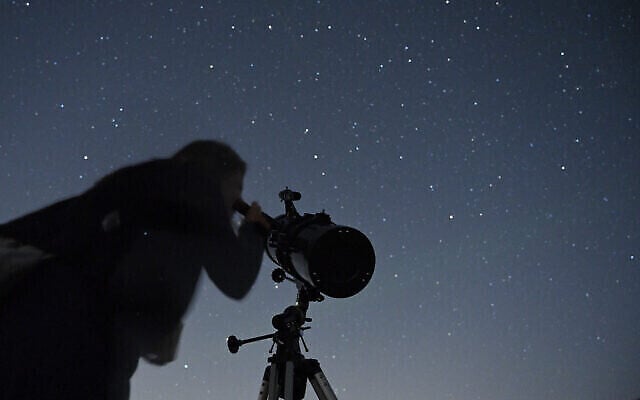 Un Israélien regarde les étoiles pendant une pluie de météorites au-dessus du plateau du Golan, le 13 août 2021. (Crédit : Michael Giladi/Flash90)