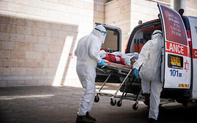 Des employés du Magen David Adom évacuent un patient soupçonné d'être atteint par la  Covid-19 à l'hôpital Hadassah Ein Karem de Jérusalem, le 15 août 2021. (Crédit :  Yonatan Sindel/Flash9)