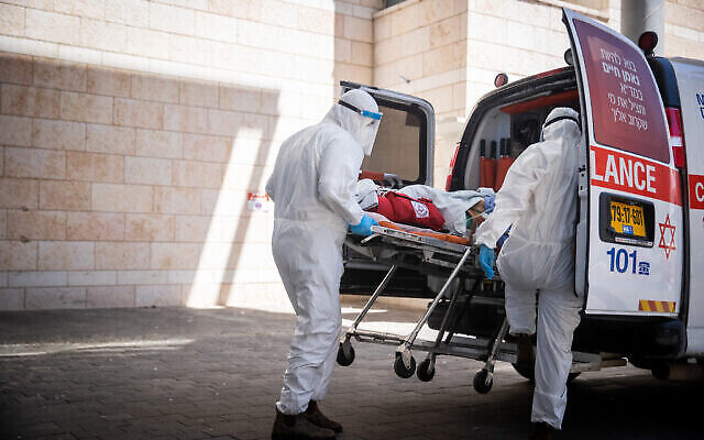 Des employés du Magen David Adom évacuent un patient soupçonné d'être atteint par la Covid-19 à l'hôpital Hadassah Ein Karem de Jérusalem, le 15 août 2021. (Crédit : Yonatan Sindel/Flash9) Des employés du Magen David Adom évacuent un patient soupçonné d'être atteint par la Covid-19 à l'hôpital Hadassah Ein Karem de Jérusalem, le 15 août 2021. (Crédit : Yonatan Sindel/Flash9)
