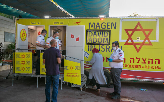 Des Israéliens font la queue pour recevoir le vaccin COVID-19 dans une unité mobile de vaccination du Magen David Adom dans la ville de Kafr Qasim, le 23 août 2021. (Crédit : Yossi Aloni/Flash90)
