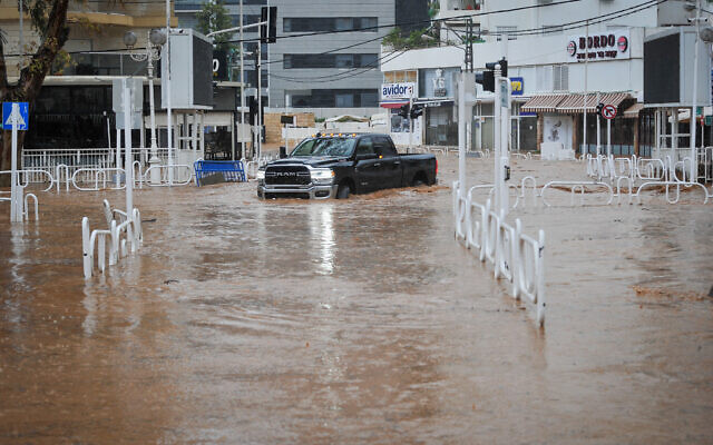 Une voiture roule sur une route inondée dans la ville de Nahariya, au nord d'Israël, le 8 janvier 2020, après qu'une rivière soit sortie de son lit. Environ 40 %, soit 250 millimètres (9,8 pouces), des précipitations annuelles moyennes de la ville sont tombées du 3 au 9 janvier de cetteannée-là. (Crédit : Meir Vaknin/Flash90)