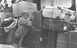 Un enfant juif immigré de Casablanca, au Maroc, avec des bagages à l'aéroport de Lod, le 24 septembre 1955. (Crédit : Eldan David/Bureau du Premier ministre)