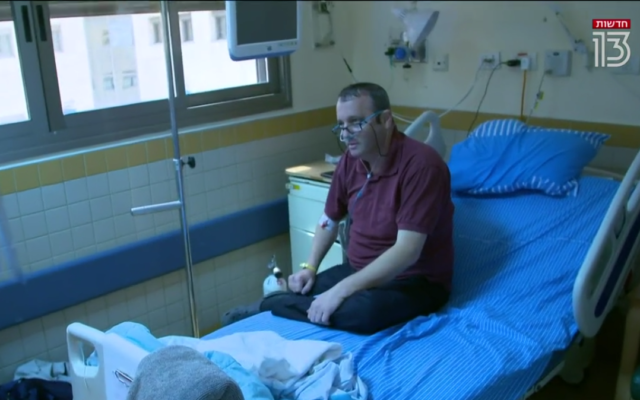 Le député travailliste Gilad Kariv s'est adressé à la Treizième chaîne depuis son lit d'hôpital dans le service de coronavirus de l'hôpital Sheba, le 18 août 2021. (Crédit : capture d'écran/Treizième chaîne)
