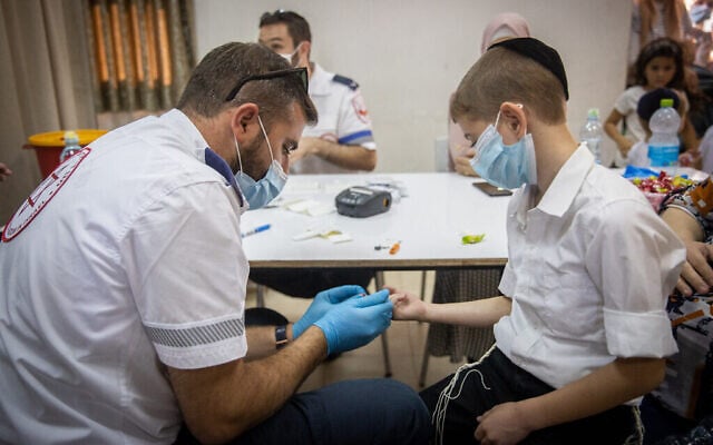 Un employé du Magen David Adom a effectué un test sérologique pour le COVID-19 dans la ville ultra-orthodoxe de Kiryat Ye'arim, le 9 août 2021 (Crédit : Yonatan Sindel/Flash90)