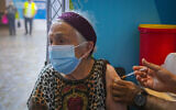Une femme israélienne de plus de 60 ans reçoit une troisième injection de vaccin contre le coronavirus dans une clinique de santé Clalit à Jérusalem, le 8 août 2021. (Crédit : Olivier Fitoussi/Flash90)