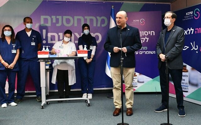 Le Premier ministre Naftali Bennett s'exprime à l'hôpital Sheba de Tel Hashomer lors du lancement de la campagne de rappel du vaccin contre le coronavirus. A sa droite, le président Isaac Herzog. (Crédit : Haim Zach / GPO) Le Premier ministre Naftali Bennett s'exprime à l'hôpital Sheba de Tel Hashomer lors du lancement de la campagne de rappel du vaccin contre le coronavirus. A sa droite, le président Isaac Herzog. (Crédit : Haim Zach / GPO)