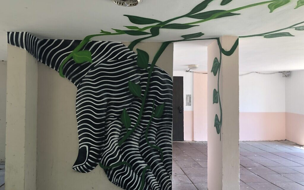 Une vigne tourbillonnante peinte sur les murs de l'entrée d'un immeuble d'habitation fait partie du musée itinérant Zumu à Lod, du 24 au 28 août 2021. (Crédit : Jessica Steinberg/Times of Israel) Une vigne tourbillonnante peinte sur les murs de l'entrée d'un immeuble d'habitation fait partie du musée itinérant Zumu à Lod, du 24 au 28 août 2021. (Crédit : Jessica Steinberg/Times of Israel)