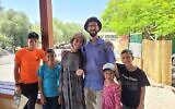 La famille Yitzchaki avec une pièce de monnaie vieille de 1500 ans qu'elle a trouvée sur le site archéologique de Korazim, dans le nord d'Israël, le 10 août 2021. (Crédit : Dekel Segev/Autorité israélienne de la nature et des parcs)