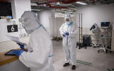 Image d'illustration : Des membres de l'équipe de l'hôpital Herzog portant des équipements de sécurité alors qu'ils travaillent dans la salle du coronavirus du centre médical Herzog à Jérusalem, le 29 juillet 2021. (Yonatan Sindel/Flash90)