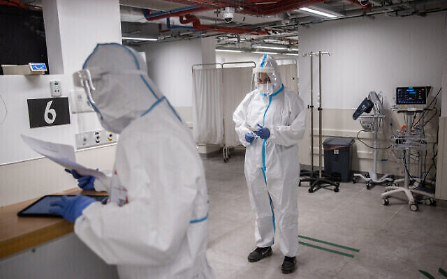 Image d'illustration : Des membres de l'équipe de l'hôpital Herzog portant des équipements de sécurité alors qu'ils travaillent dans la salle du coronavirus du centre médical Herzog à Jérusalem, le 29 juillet 2021. (Yonatan Sindel/Flash90) Image d'illustration : Des membres de l'équipe de l'hôpital Herzog portant des équipements de sécurité alors qu'ils travaillent dans la salle du coronavirus du centre médical Herzog à Jérusalem, le 29 juillet 2021. (Yonatan Sindel/Flash90)