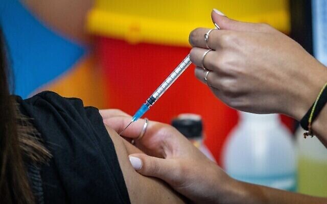 Une femme reçoit sa troisième dose du vaccin COVID-19 dans une clinique des services de santé Clalit à Jérusalem, le 29 août 2021. (Yonatan Sindel/Flash90)