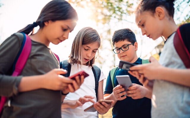 Photo d'illustration : Des enfants sur leur téléphone mobile. (Crédit : Kerkez/iStock by Getty Images) Photo d'illustration : Des enfants sur leur téléphone mobile. (Crédit : Kerkez/iStock by Getty Images)