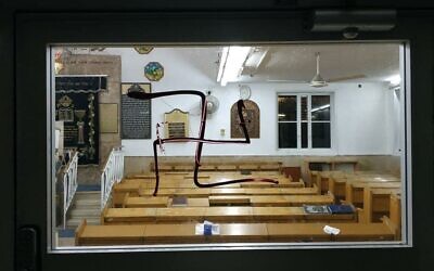 Une croix gammée peinte sur la porte d'une synagogue à Bnei Brak, le 31 juillet 2021. (Crédit : Police israélienne) Une croix gammée peinte sur la porte d'une synagogue à Bnei Brak, le 31 juillet 2021. (Crédit : Police israélienne)