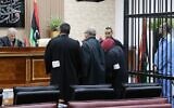 Saadi Kadhafi, à droite, le fils de feu le dictateur Mouammar Kadhafi,  dans la cellule des accusés pendant son procès à Tripoli, en Libye, le 13 mars 2016. (Crédit :  MAHMUD TURKIA / AFP)