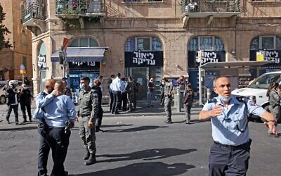 Des agents de police israéliens sur le site d'une attaque au couteau à Jérusalem, le 13 septembre 2021. (Crédit : AHMAD GHARABLI / AFP)