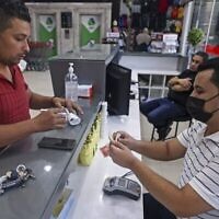 Un Palestinien recevant une aide financière versée par le Qatar dans un supermarché de Gaza City, le 15 septembre 2021. (Crédit : Mahmud Hams/AFP)