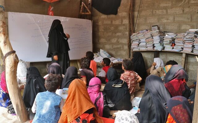 L'enseignante yéménite Amina Mahdi (à gauche) donne une leçon à des enfants affalés sur le sol de sa maison dans la zone rurale de Muhib, dans la province méridionale de Hodeida, le 1er septembre 2021. (Photo de - / AFP) L'enseignante yéménite Amina Mahdi (à gauche) donne une leçon à des enfants affalés sur le sol de sa maison dans la zone rurale de Muhib, dans la province méridionale de Hodeida, le 1er septembre 2021. (Photo de - / AFP)
