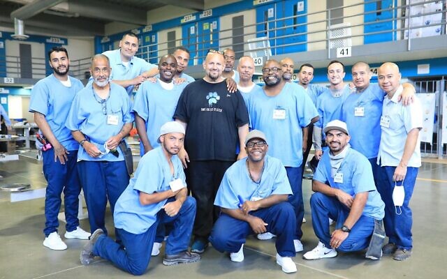 Jon Grobman (au centre) pose avec un groupe de détenus à la prison d'État de Californie, dans le comté de Los Angeles, à Lancaster. Sa peine de prison terminée, Grobman travaille maintenant comme directeur des programmes pour Paws for Life K9 Rescue, qui forme des détenus à dresser des chiens. (Autorisation de Rita Earl Blackwell, via JTA)