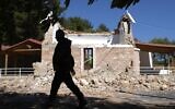 Un résident passe devant une église grecque orthodoxe endommagée après un fort séisme dans le village d'Arcalochori, en Crète, une île du sud de la Grèce, le 27 septembre 2021. (Crédit : AP Photo/Harry Nikos)