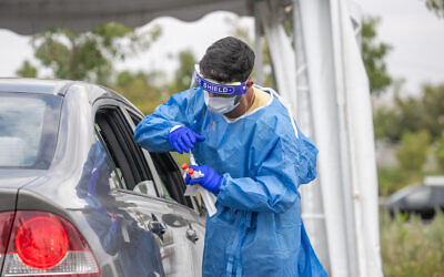 Des employés pratiquent des tests à la COVID-19 dans un centre de dépistage de type Drive-in à Modiin, le 10 septembre 2021. (Crédit : Yossi Aloni/Flash90)