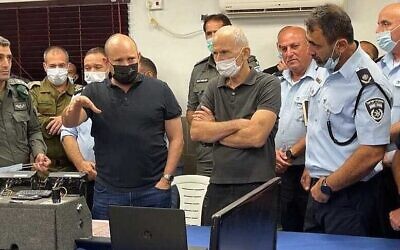 Le Premier ministre Naftali Bennett, à gauche, et le ministre de la Sécurité intérieure Omer Barlev avec les commandants de la police pendant la traque des six prisonniers palestiniens évadés de la prison de Gilboa, le 11 septembre 2021. (Crédit : Police israélienne)