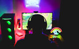 Illustration : Un jeune homme portant un casque et jouant à un jeu vidéo en ligne. (Crédit : DisobeyArt/iStock by Getty Images)