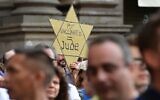 Illustration : Un manifestant tient une étoile jaune sur laquelle on peut lire "Pas de vaccin = Juif" alors que des manifestants prennent part à une manifestation à Milan, le 24 juillet 2021, contre l'introduction d'un "laissez-passer vert" obligatoire pour les restaurants intérieurs et les lieux de divertissement, dans le but de limiter la propagation du coronavirus. (Crédit : MIGUEL MEDINA / AFP)