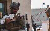 Matt Jaffe sourit à un bébé à l'aéroport de Kaboul en Afghanistan, vendredi 20 août 2021, dans une photo devenue virale. (Sergent Isaiah Campbell du Commandement central des États-Unis/US Marine Corps)