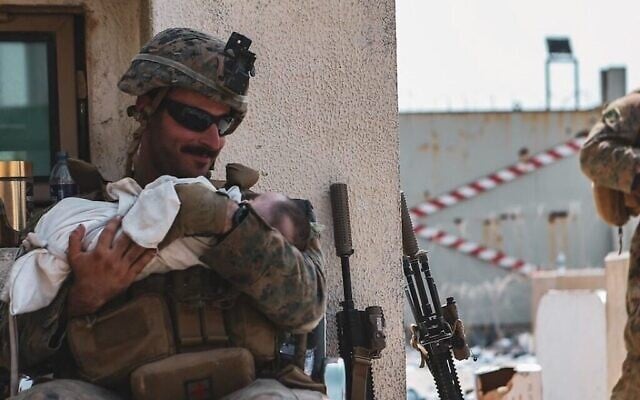 Matt Jaffe sourit à un bébé à l'aéroport de Kaboul en Afghanistan, vendredi 20 août 2021, dans une photo devenue virale. (Sergent Isaiah Campbell du Commandement central des États-Unis/US Marine Corps) Matt Jaffe sourit à un bébé à l'aéroport de Kaboul en Afghanistan, vendredi 20 août 2021, dans une photo devenue virale. (Sergent Isaiah Campbell du Commandement central des États-Unis/US Marine Corps)