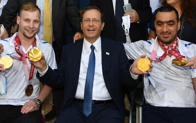 Le président Isaac Herzog pose pour une photo avec les médaillés paralympiques Mark Malyar (à gauche) et Iyad Shalabi (à droite) à la résidence du président à Jérusalem, le 14 septembre 2021. (Amos Ben Gershom/GPO) Le président Isaac Herzog pose pour une photo avec les médaillés paralympiques Mark Malyar (à gauche) et Iyad Shalabi (à droite) à la résidence du président à Jérusalem, le 14 septembre 2021. (Amos Ben Gershom/GPO)