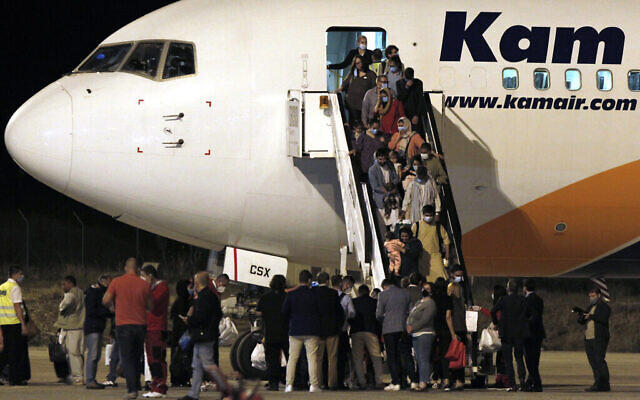 Des personnes évacuées d'Afghanistan débarquent d'un avion après avoir atterri à l'aéroport international de Skopje, en Macédoine du Nord, le 30 août 2021. (AP Photo/Boris Grdanoski)