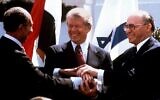 Le président égyptien Anouar el-Sadate, à gauche, le président américain Jimmy Carter, au centre, et le Premier ministre Menachem Begin se serrant la main sur la pelouse nord de la Maison Blanche après avoir signé le traité de paix entre l'Égypte et Israël, le 26 mars 1979. (Crédit : Bob Daugherty/AP/Dossier)