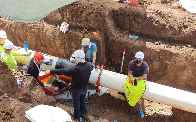 Des ouvriers réparant une section de tuyau dans le sud d'Israël, appartenant à la société Europe Asia Pipeline Company, suite à une fuite de pétrole brut, le 30 août 2021. (Crédit : Ministère de l'Environnement)