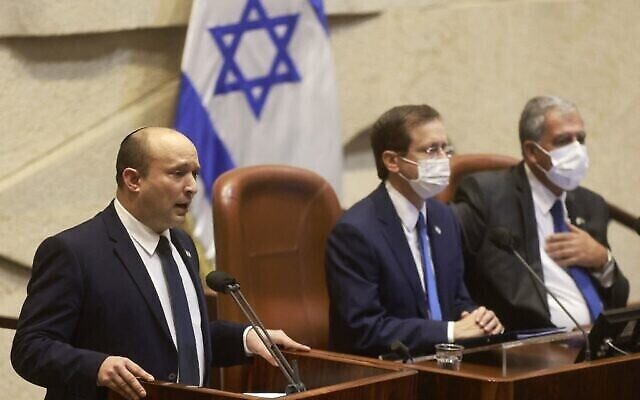 Le Premier ministre Naftali Bennett à côté du président israélien Isaac Herzog lors d'un discours à la Knesset à Jérusalem, le 4 octobre 2021. (Crédit :   Menahem KAHANA / AFP)