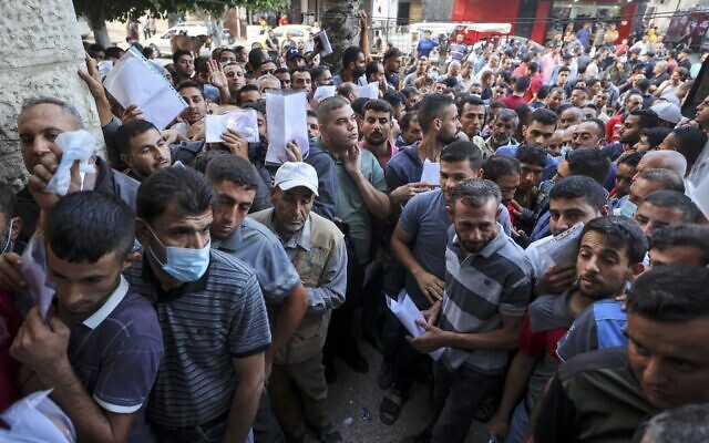 Des Palestiniens se rassemblent pour demander des permis de travail en Israël, au camp de réfugiés de Jabalia, dans le nord de la bande de Gaza, le 6 octobre 2021. (Crédit : Mahmud Hams / AFP) Des Palestiniens se rassemblent pour demander des permis de travail en Israël, au camp de réfugiés de Jabalia, dans le nord de la bande de Gaza, le 6 octobre 2021. (Crédit : Mahmud Hams / AFP)