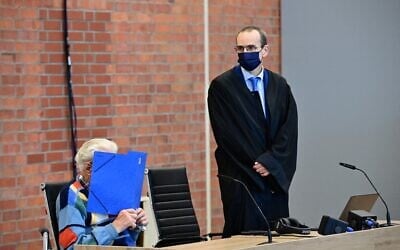 L'accusé Josef S (G) est assis à côté de son avocat Stefan Waterkamp et cache son visage derrière un dossier alors qu'il attend le début de son procès à Brandenburg an der Havel, dans le nord-est de l'Allemagne, le 7 octobre 2021 (Crédit : Tobias Schwarz / AFP)