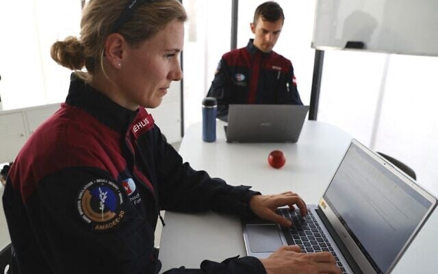 (De gauche à droite) L'astronaute allemande Anika Mehlis et son collègue autrichien Robert Wild utilisent des ordinateurs portables avant une mission d'entraînement pour la planète Mars sur un site qui simule une station hors site au cratère Ramon à Mitzpe Ramon, dans le sud du désert du Néguev en Israël, le 10 octobre 2021. (Crédit :  Jack Guez/AFP)