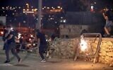 Des manifestants palestiniens alors qu'une grenade assourdissante explose lors d'une manifestation dans la Vieille Ville de Jérusalem, le 10 octobre 2021. (Crédit : AHMAD GHARABLI / AFP)