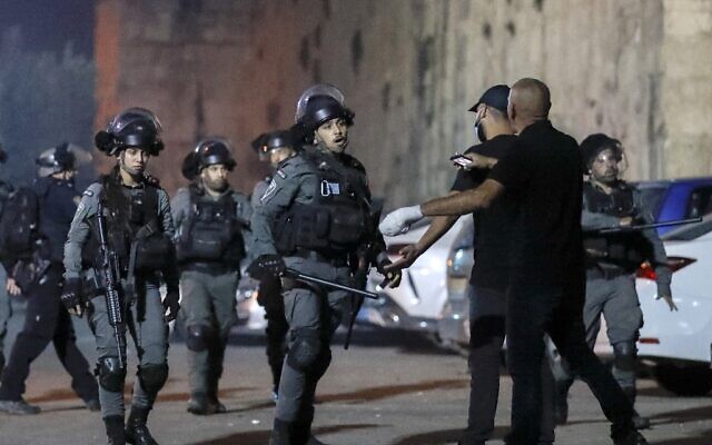 Des agents de la police des frontières affrontent des Palestiniens près de la porte du Lion, dans la Vieille Ville de Jérusalem, le 10 octobre 2021. (Crédit : AHMAD GHARABLI / AFP)