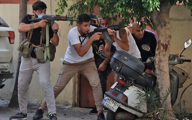 Des combattants des groupes terroristes chiites Hezbollah et Amal prennent pour cible lors d'affrontements dans la zone de Tayouneh, dans la banlieue sud de la capitale Beyrouth, le 14 octobre 2021. (Crédit : Anwar AMRO / AFP) Des combattants des groupes terroristes chiites Hezbollah et Amal prennent pour cible lors d'affrontements dans la zone de Tayouneh, dans la banlieue sud de la capitale Beyrouth, le 14 octobre 2021. (Crédit : Anwar AMRO / AFP)