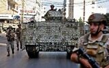 Des soldats de l'armée libanaise patrouillent dans la zone des affrontements dans la banlieue sud de la capitale Beyrouth, le 14 octobre 2021. (Crédit :  ANWAR AMRO / AFP)